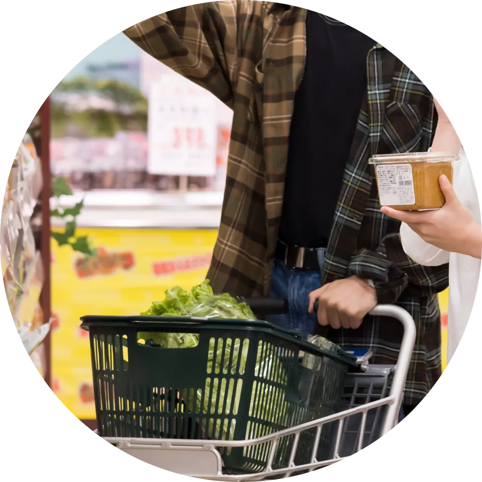 スーパーマーケットで買い物かごを使って食品を選ぶ様子